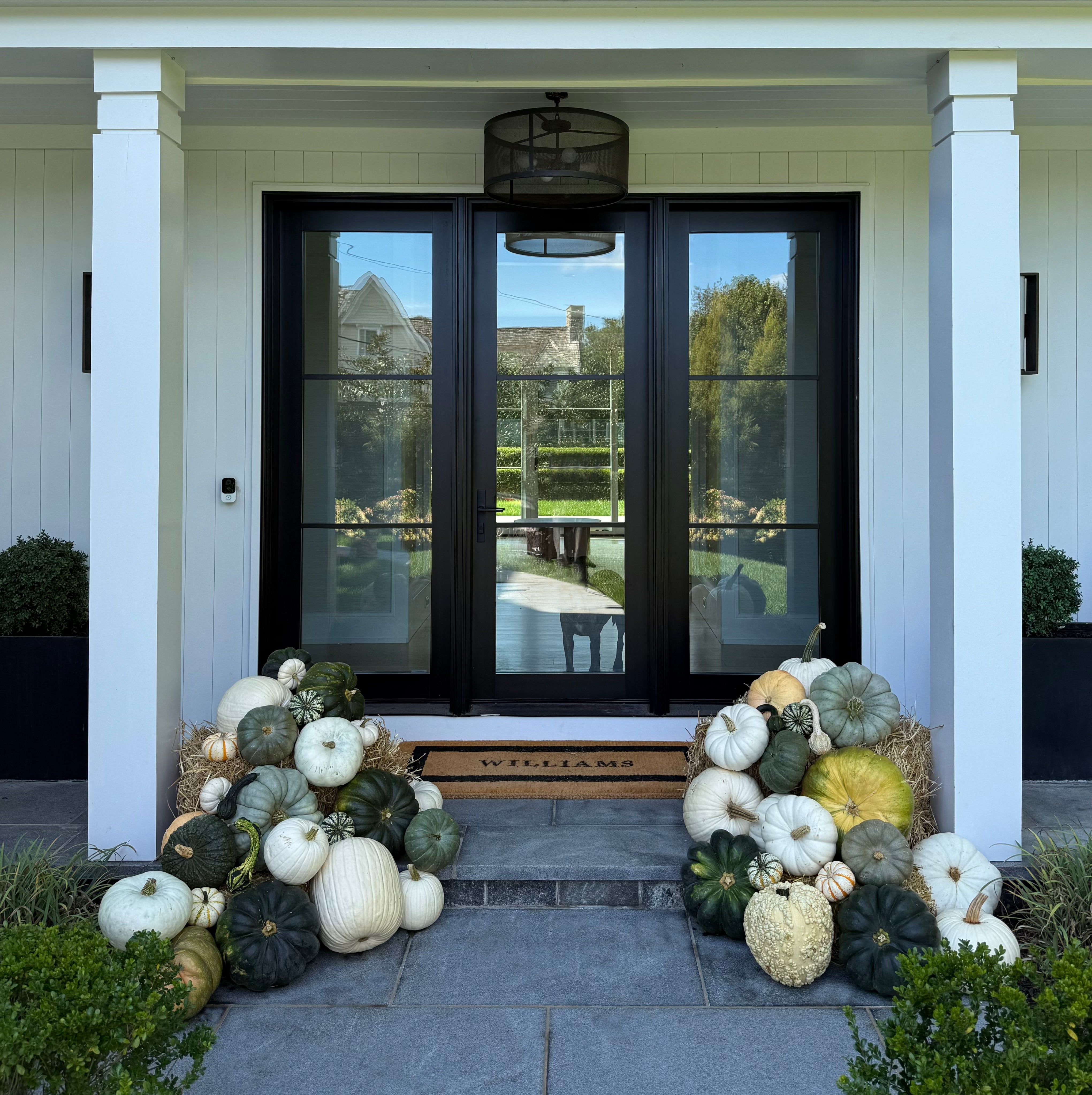 Decorative pumpkins on a front porch with a house in the background in Westport Fairfield County Connecticut